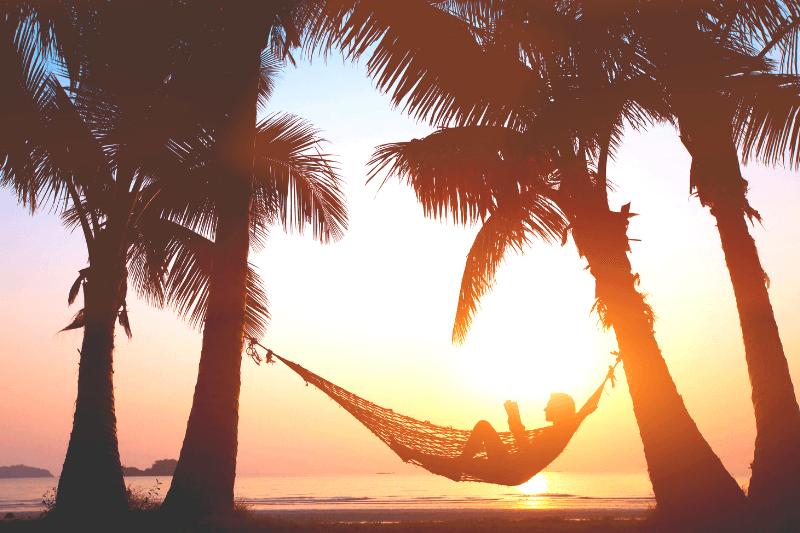 Beach Vacation Packing List the Essentials | Relaxing at the beach on a hammock